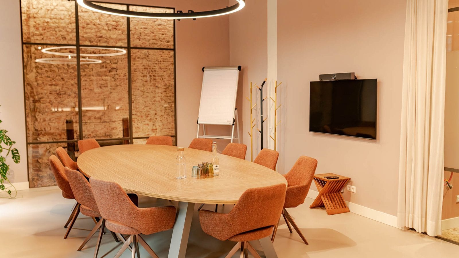 De Herenkamer van Kunstkamer Utrecht: ovale vergadertafel met zicht op de monumentale muur van stadskasteel Drakenburg